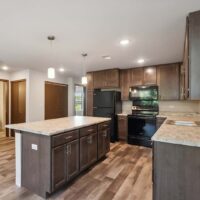 Modern kitchen with dark wood cabinets, black appliances, a large center island, pendant lighting, and wood-style flooring.