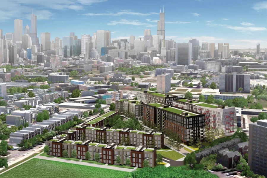 Aerial view of a new residential development with green rooftops in a city, with a downtown skyline and skyscrapers in the background.