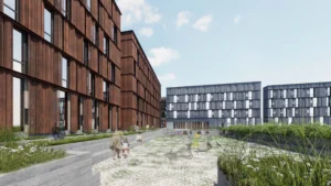 A modern courtyard with people walking and greenery, surrounded by multi-story brown and gray buildings under a partly cloudy sky.