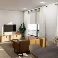 Modern living room with a brown sofa, TV on a light wood stand, large windows with sheer curtains, indoor plant, and a dining table with beige chairs and a flower arrangement.