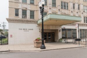Entrance to The Bryn Mawr apartment building at 5550 with a prominent black street lamp and a green marquee.