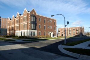 Two three-story brick apartment buildings situated on a corner lot.