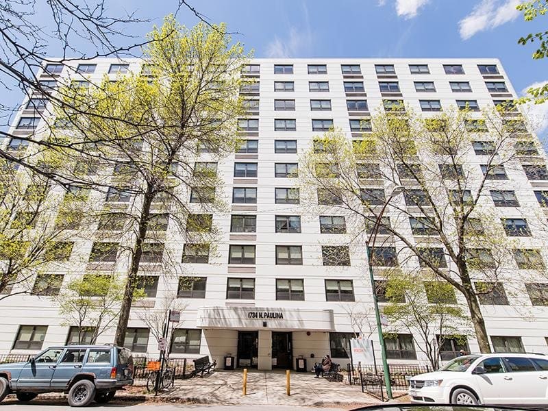 A ten-story apartment building at 1734 N. Paulina with vehicles parked in front.